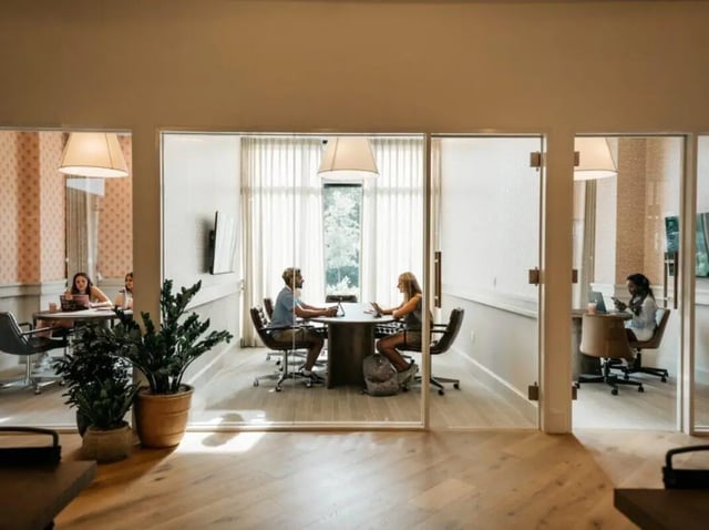 Students working at tables in glass rooms study area at Rambler Athens in Atlanta Student Accommodation
