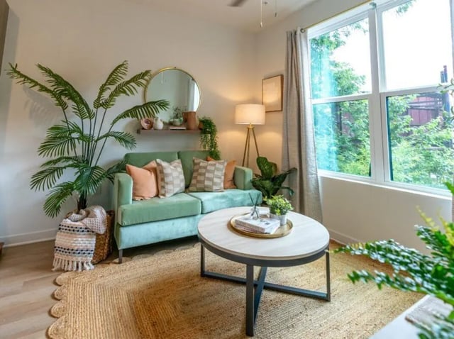 Green sofa coffee table plants living room at Rambler Athens in Atlanta Student Accommodation