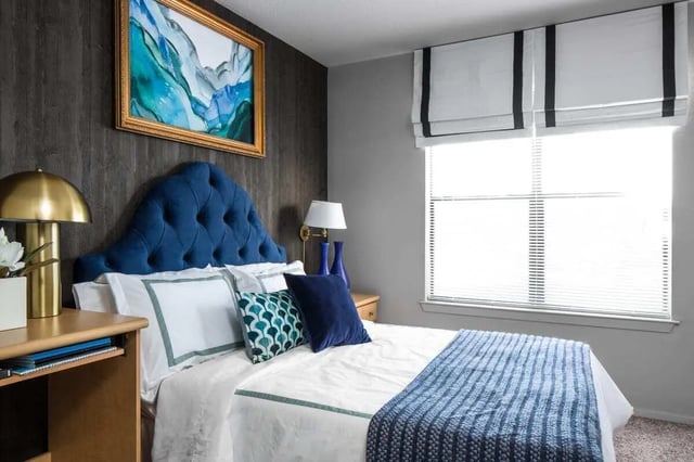 Blue tufted headboard white bedding blue throw bedroom at The London in College Station Student Accommodation