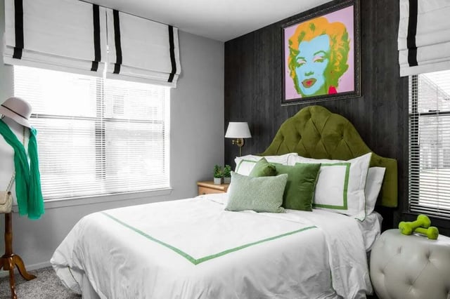 Bed with green tufted headboard Marilyn Monroe artwork Bedroom at The London in College Station Student Accommodation