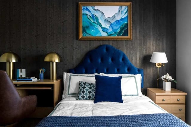 Blue velvet headboard bed lamps desk painting bedroom at The London in College Station Student Accommodation