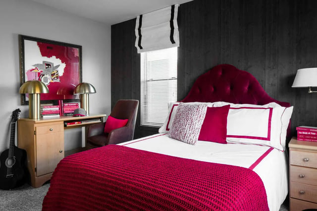 Bed with red blanket and study desk bedroom at The London in College Station Student Accommodation