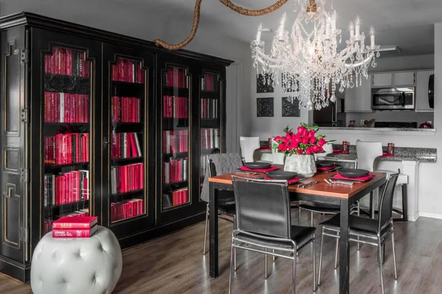 Black bookcase dining table flowers and chairs dining area at The London in College Station Student Accommodation