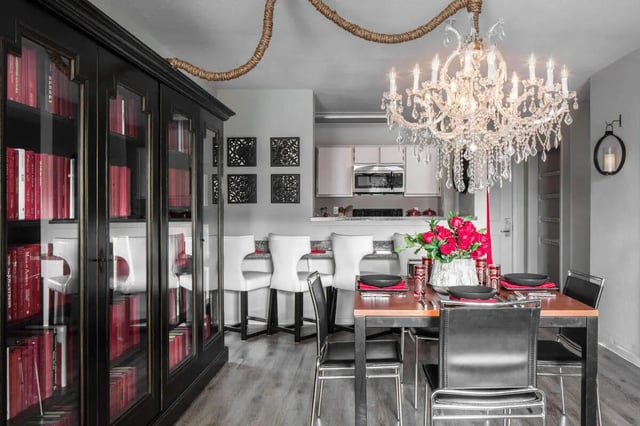 Bookshelf dining table chandelier and kitchen area at The London in College Station Student Accommodation