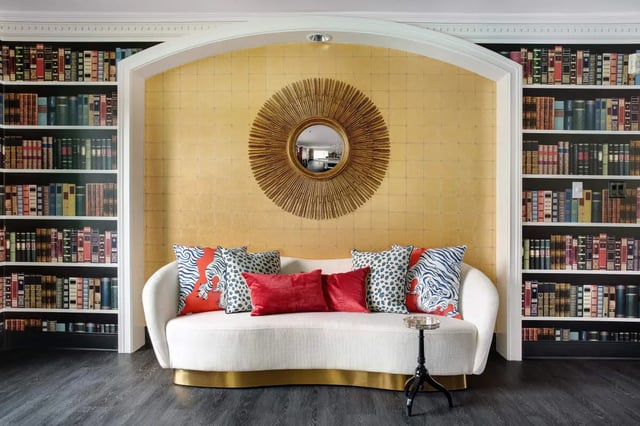 Sofa bookshelf mirror and sunburst decor living room at The London in College Station Student Accommodation