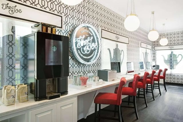 Starbucks machine coffee cups red chairs computers lounge area at The London in College Station Student Accommodation