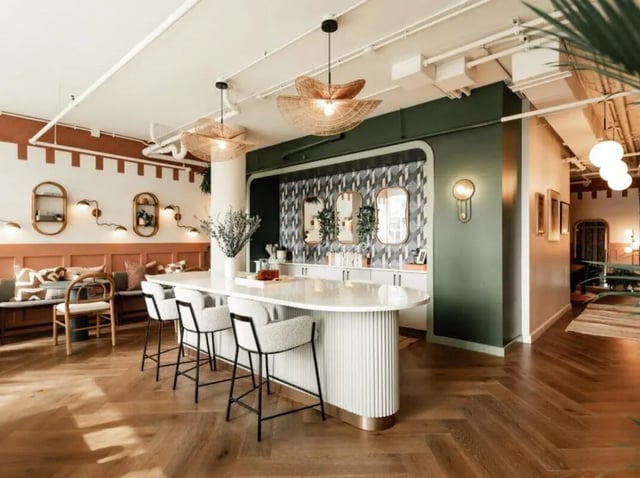 Bar stools at island with patterned wallpaper and mirrors communal area at Rambler Atlanta in Atlanta Student Accommodation