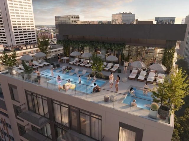 Rooftop pool lounge chairs umbrellas and people recreation area at Rambler Atlanta in Atlanta Student Accommodation