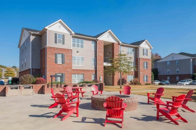 Red chairs around fire pit exterior at The Reserve in Carrollton Student Accommodation