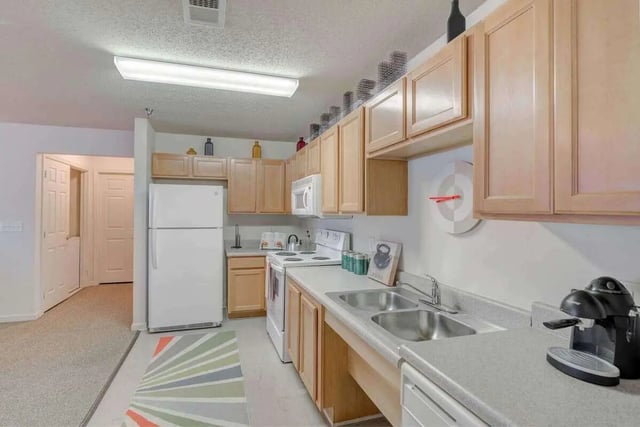 Refrigerator stove cabinets double sink kitchen at The Reserve in Carrollton Student Accommodation