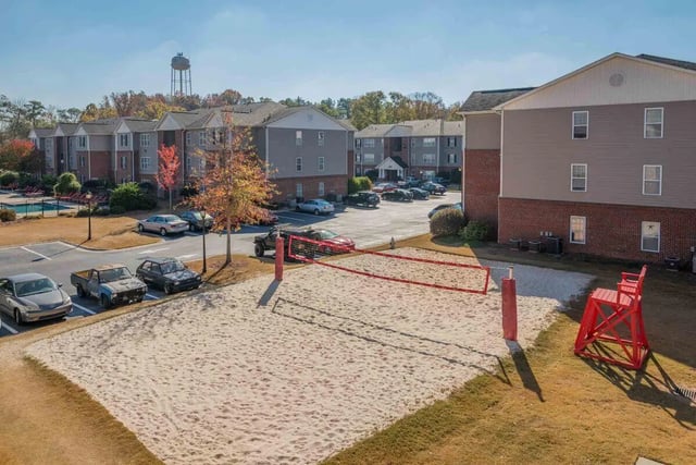 Volleyball court with red net and chairs exterior at The Reserve in Carrollton Student Accommodation