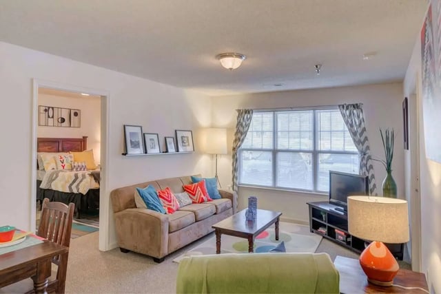 Sofa coffee table TV and bedroom view living room at The Reserve in Carrollton Student Accommodation