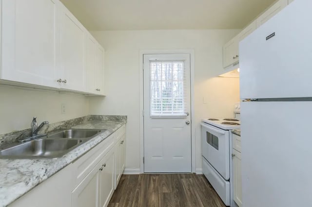 White cabinets double sink stove and refrigerator kitchen at Belmont Crossing in Smyrna Student Accommodation