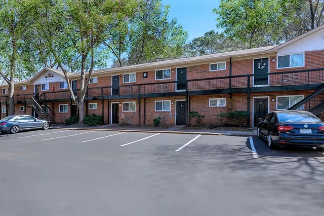 Brick apartment building with cars and parking exterior at Belmont Crossing in Smyrna Student Accommodation