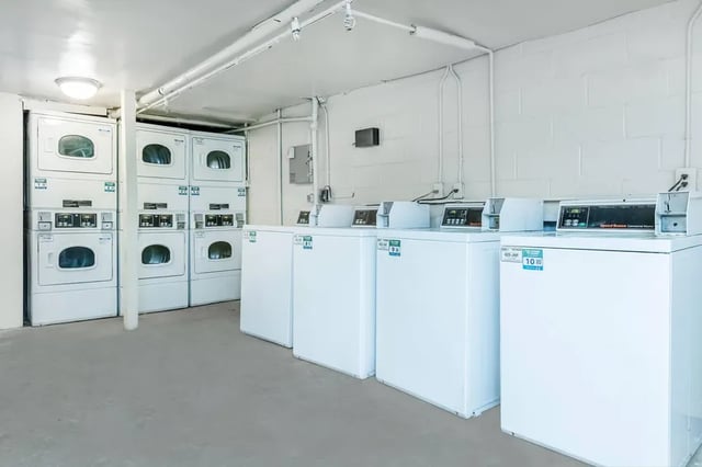 Stacked and side-by-side washing machines laundry area at Villas De Las Colinas 1 in Atlanta Student Accommodation