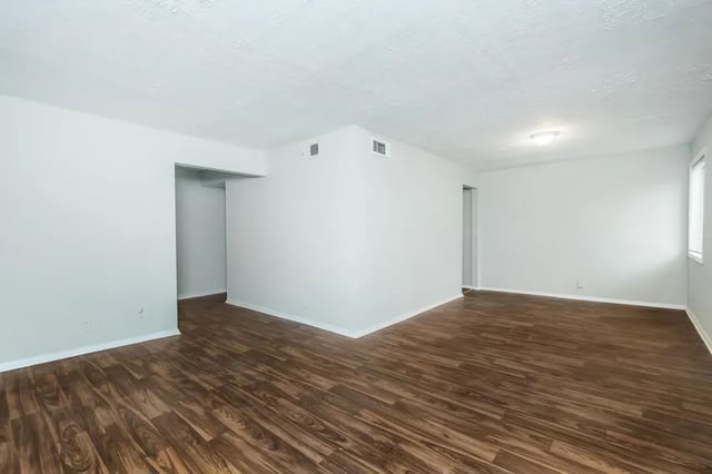 White walls wood floors empty living room at Villas De Las Colinas 1 in Atlanta Student Accommodation