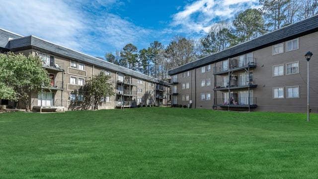Apartment buildings with balconies and green lawn exterior at Villas De Las Colinas 1 in Atlanta Student Accommodation