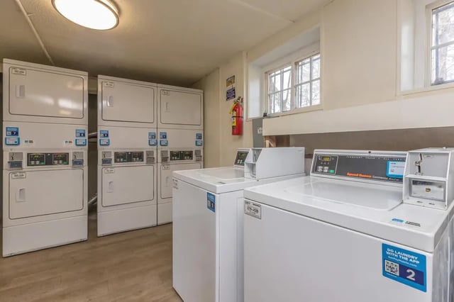 White washers and dryers stacked and in a row laundry room at Villas De Las Colinas 2 in Atlanta Student Accommodation
