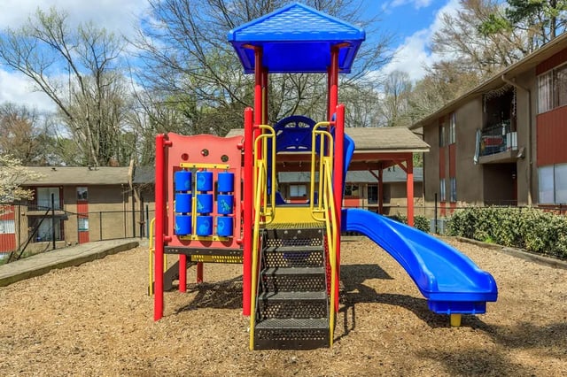 Colorful playground with blue slide and climbing wall playing area at Villas De Las Colinas 3 in Atlanta Student Accommodation