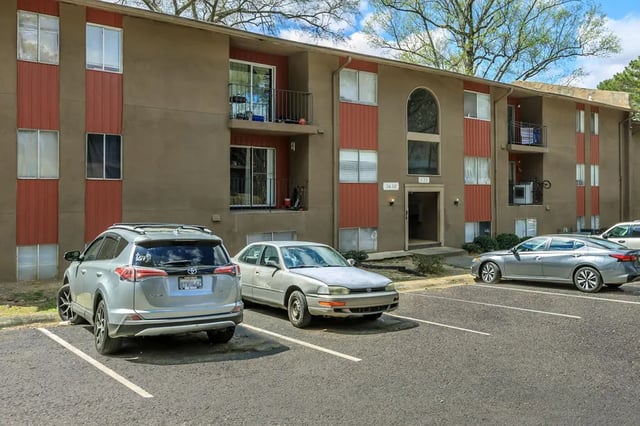 Apartment building with cars parked outside Exterior at Villas De Las Colinas 3 in Atlanta Student Accommodation
