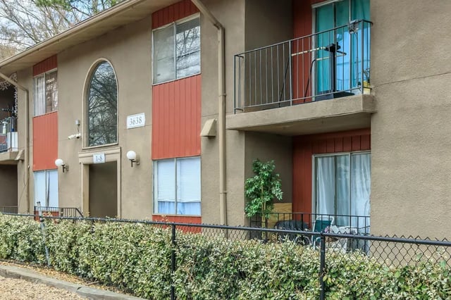 Apartment building exterior with balconies and green hedge Exterior at Villas De Las Colinas 3 in Atlanta Student Accommodation