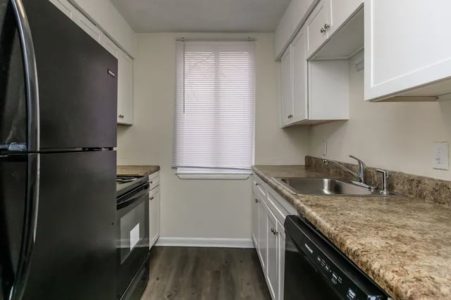 Black refrigerator oven sink cabinets window kitchen at Villas De Las Colinas 4 in Atlanta Student Accommodation
