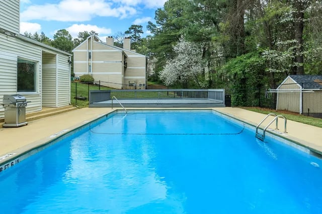 Swimming pool deck with grill and buildings exterior at Villas De Las Colinas 4 in Atlanta Student Accommodation
