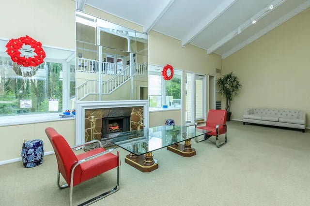 Fireplace two red chairs glass table white couch living room at Villas De Las Colinas 4 in Atlanta Student Accommodation