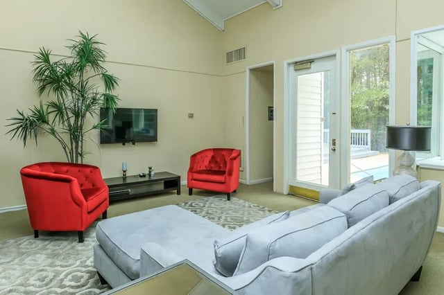 Sofa two red chairs TV plant living room at Villas De Las Colinas 4 in Atlanta Student Accommodation
