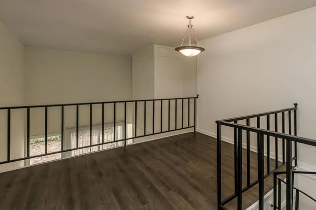 Hallway with dark wood floor and railing hallway at Villas De Las Colinas 4 in Atlanta Student Accommodation