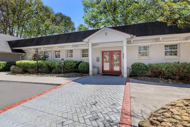 Building entrance with red doors and brick exterior exterior at Villas De Solana in Atlanta Student Accommodation