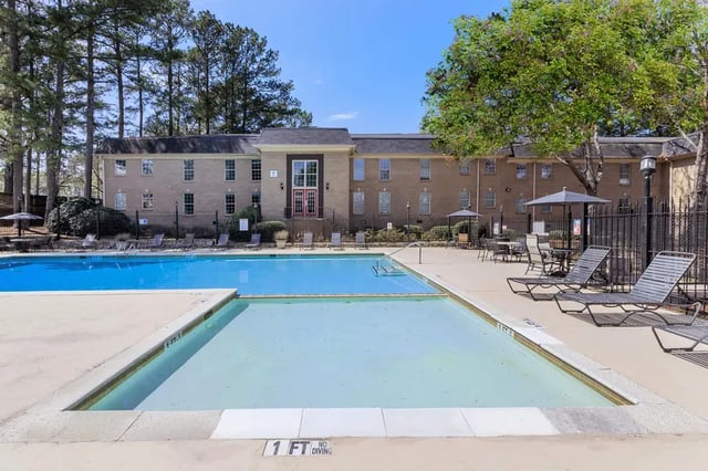 Apartment building and swimming pool with lounge chairs exterior at Villas De Solana in Atlanta Student Accommodation