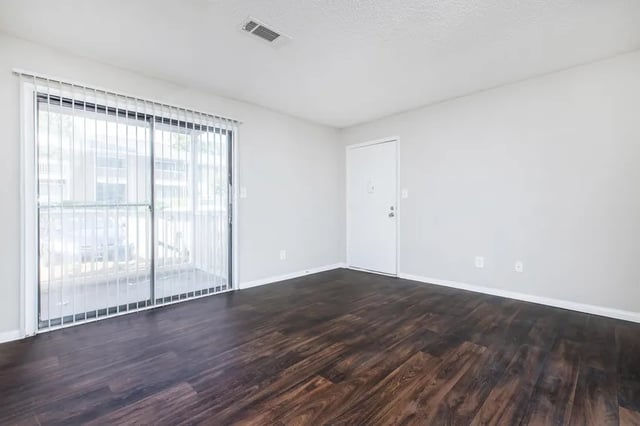 Sliding glass door white door dark floor living room at Villas Del Mirasol in Roswell Student Accommodation