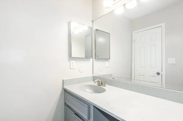 Sink cabinet mirrors lights and door bathroom at Villas Del Mirasol in Roswell Student Accommodation