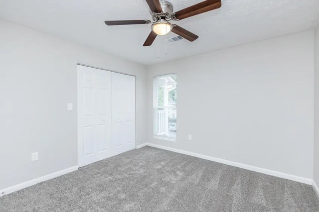 Closet ceiling fan window grey carpet bedroom at Villas Del Mirasol in Roswell Student Accommodation