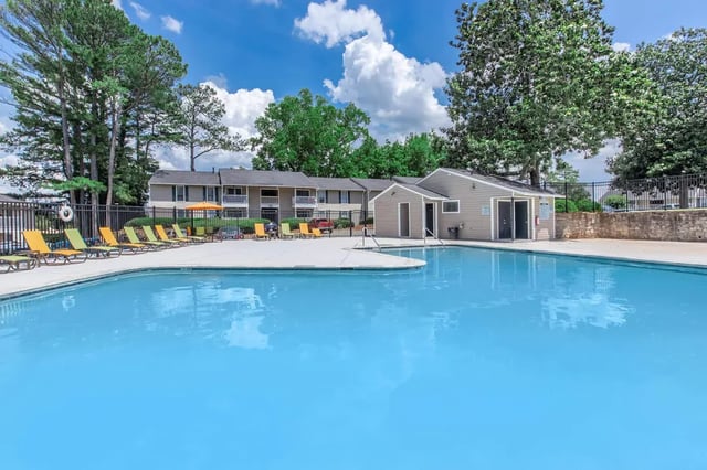 Pool deck with lounge chairs and apartment buildings exterior at Villas Del Mirasol in Roswell Student Accommodation