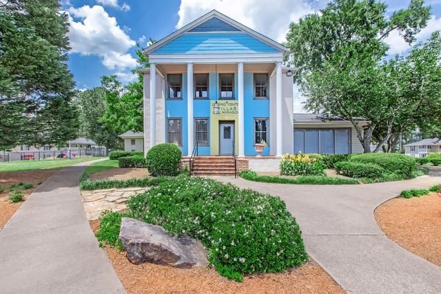 Blue building with columns and landscaping exterior at Villas Del Mirasol in Roswell Student Accommodation