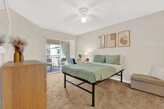 Bed with green bedding desk and dresser bedroom at on50 Tampa Apartments in Tampa Student Accommodation
