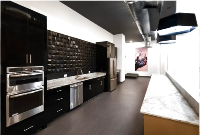 Black cabinets stainless steel appliances textured wall kitchen at Altitude Apartments Harrisonburg in Harrisonburg Student Accommodation