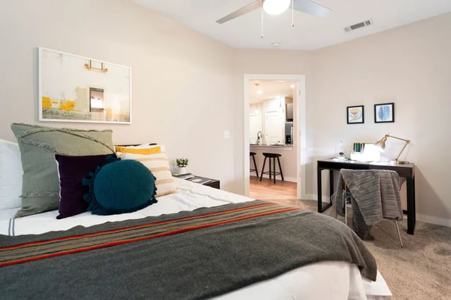 Bed desk with lamp art and open kitchen bedroom at The Indy Apartments in Marietta Student Accommodation