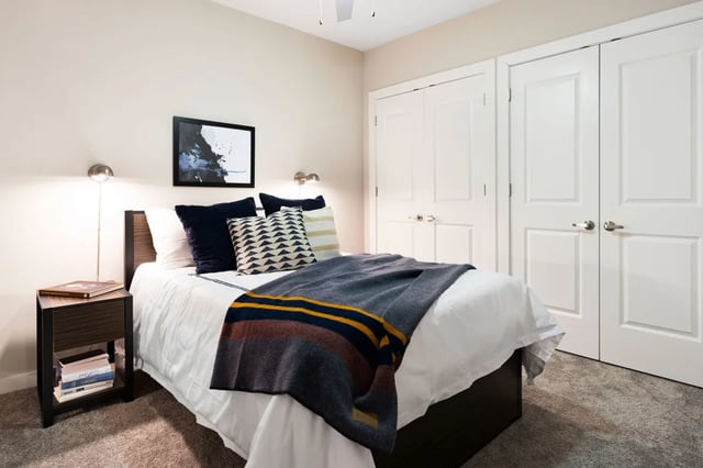 Bed with pillows blanket bedside table closet bedroom at The Indy Apartments in Marietta Student Accommodation