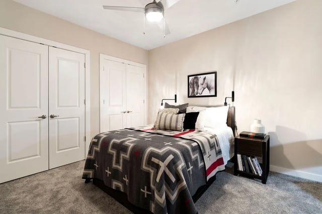 Bed with patterned blanket nightstand and doors bedroom at The Indy Apartments in Marietta Student Accommodation