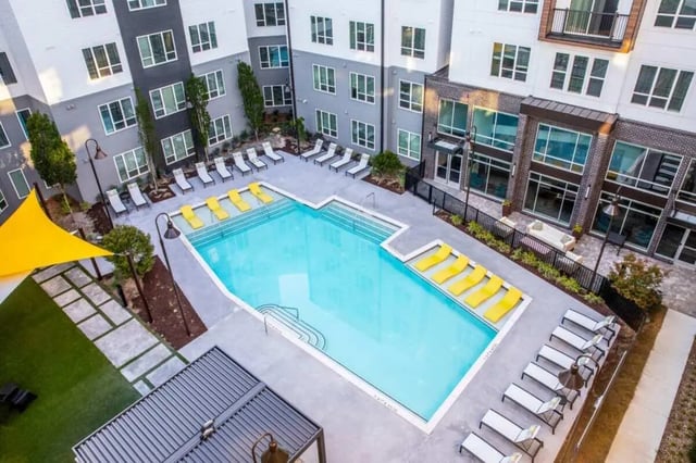 Pool with lounge chairs and building exterior at The Indy Apartments in Marietta Student Accommodation