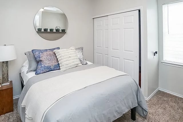 Bed with pillows closet and mirror bedroom at The Leonard Denton in Denton Student Accommodation