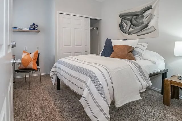 Bed with striped bedding and pillows bedroom at The Leonard Denton in Denton Student Accommodation