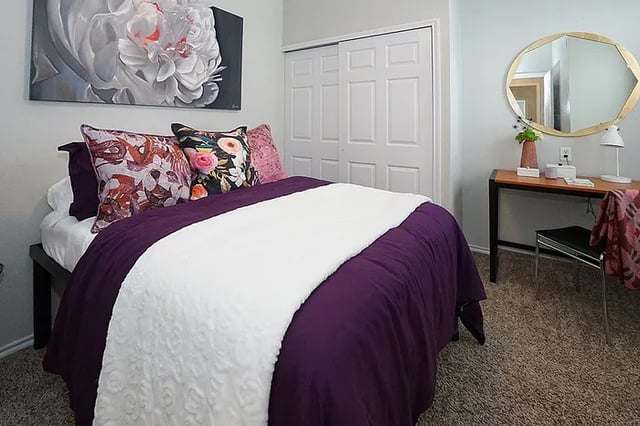 Bed with purple bedding desk with mirror bedroom at The Leonard Denton in Denton Student Accommodation