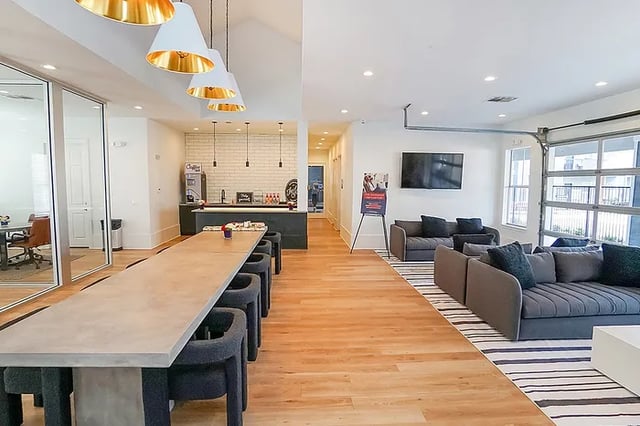 Long table coffee bar sofas television lounge area at The Leonard Denton in Denton Student Accommodation