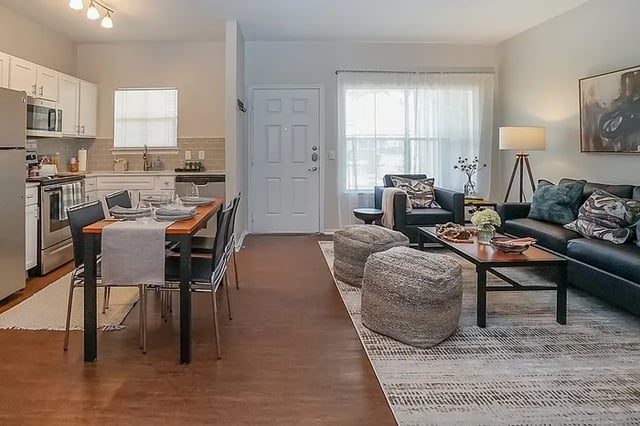 Dining table chairs kitchen and living area at The Leonard Denton in Denton Student Accommodation