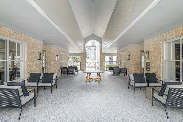 Seating areas and round table covered patio area at The Leonard Denton in Denton Student Accommodation