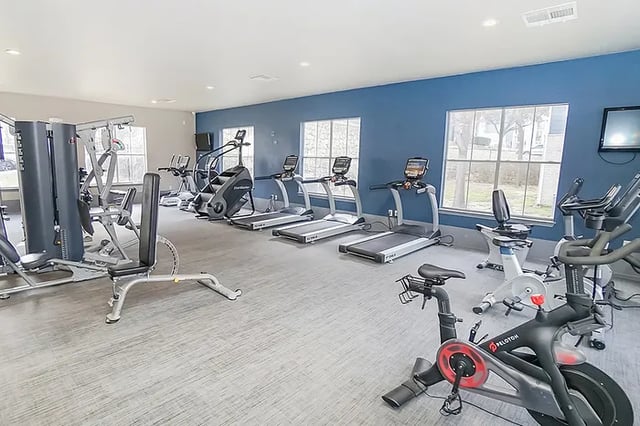 Treadmills stationary bikes and weight machine gym area at The Leonard Denton in Denton Student Accommodation